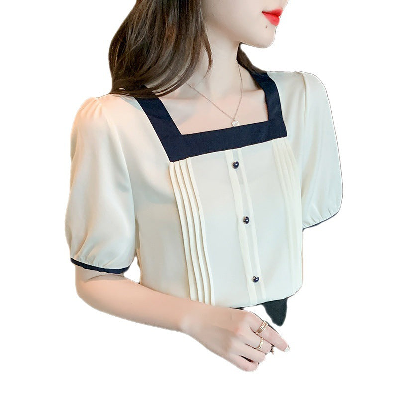 Chic blus med plisseringar och kontrasterande detaljer