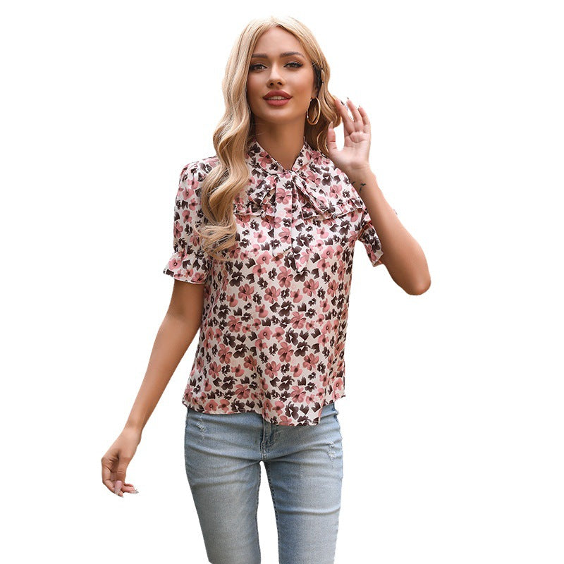 Feminin blus med blomstermönster och delikata rosettdetaljer