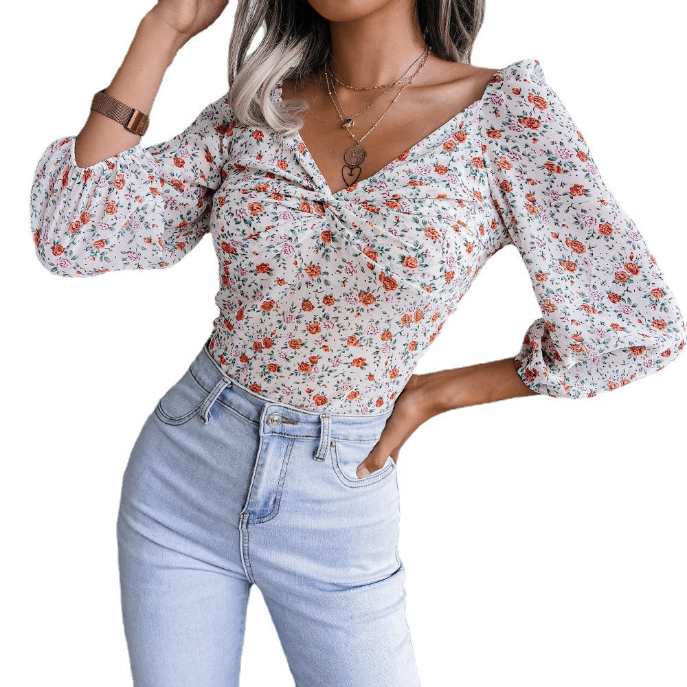 Elegant blus med tidsenligt blommönster och knytdetalj