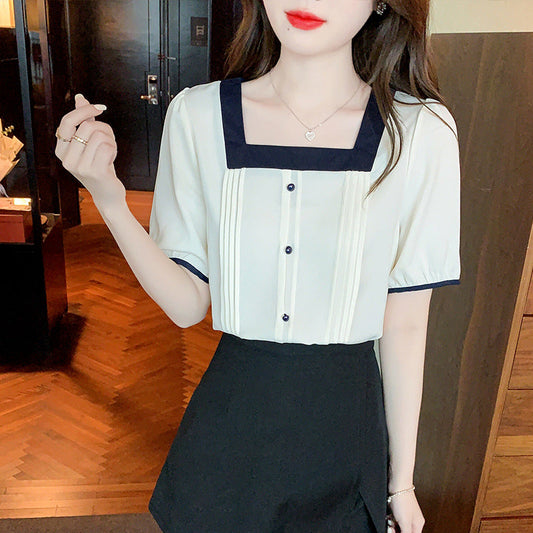 Chic blus med plisseringar och kontrasterande detaljer
