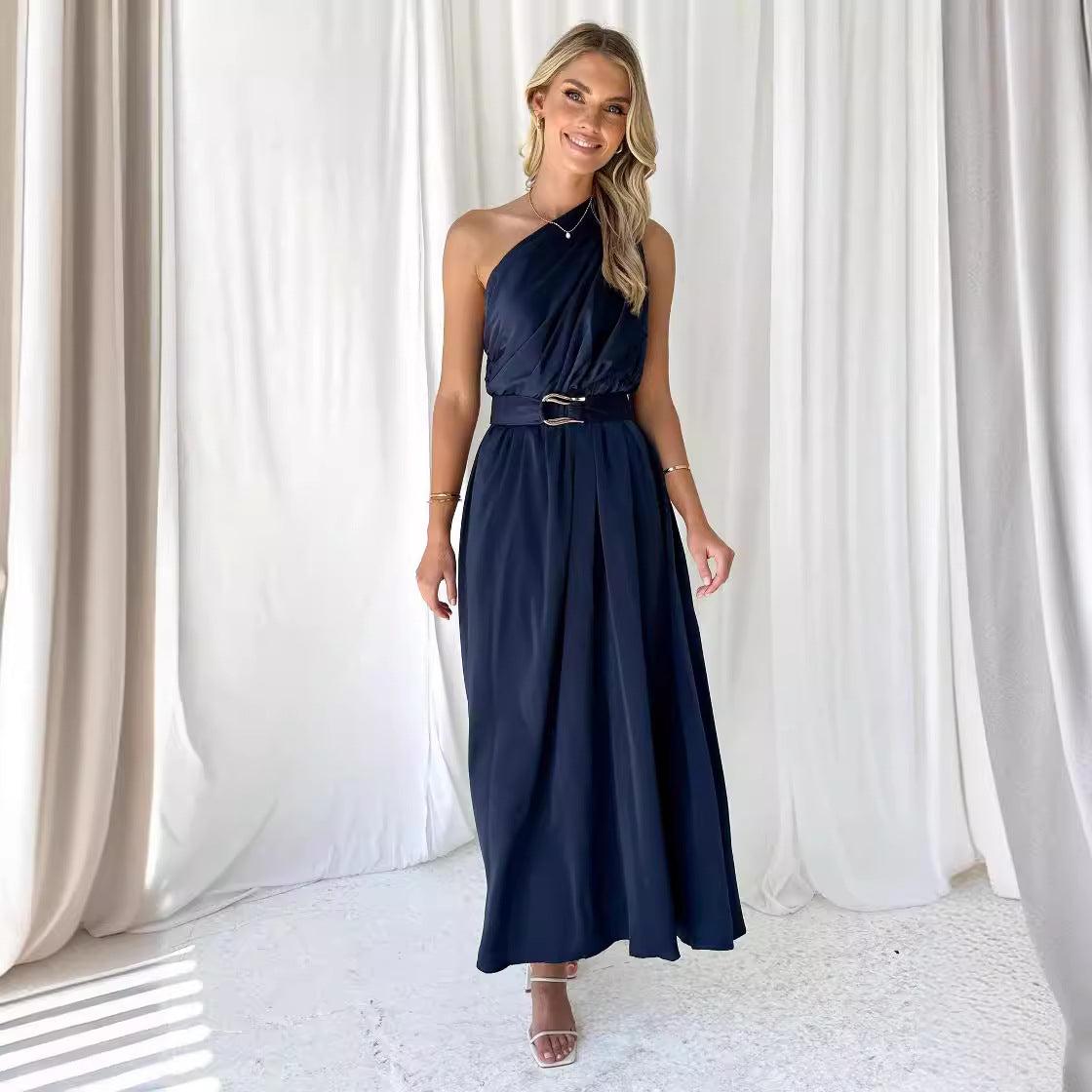 Elegant aftonklänning med asymmetrisk axelrem och stilfull midja
