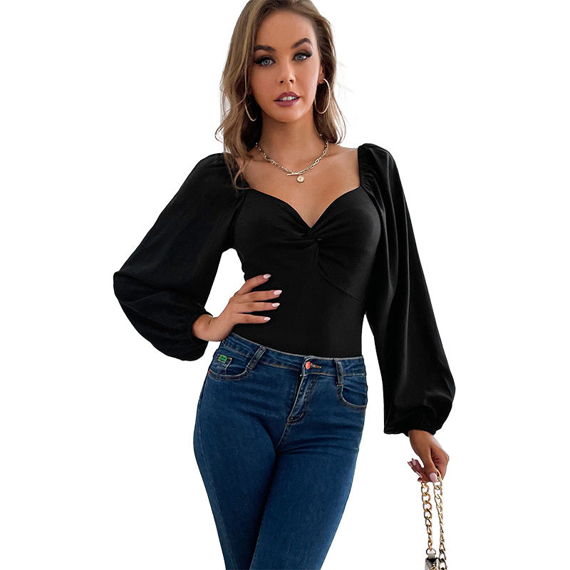 Chic body med voluminösa ärmar och elegant knappdetalj